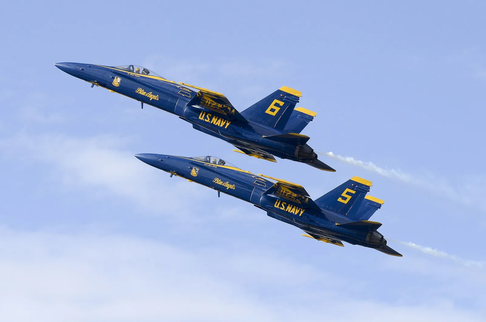 Two Blue Angels F/A-18 Hornets climb in formation during the Blue Angels Homecoming Air Show at Naval Air Station Pensacola.