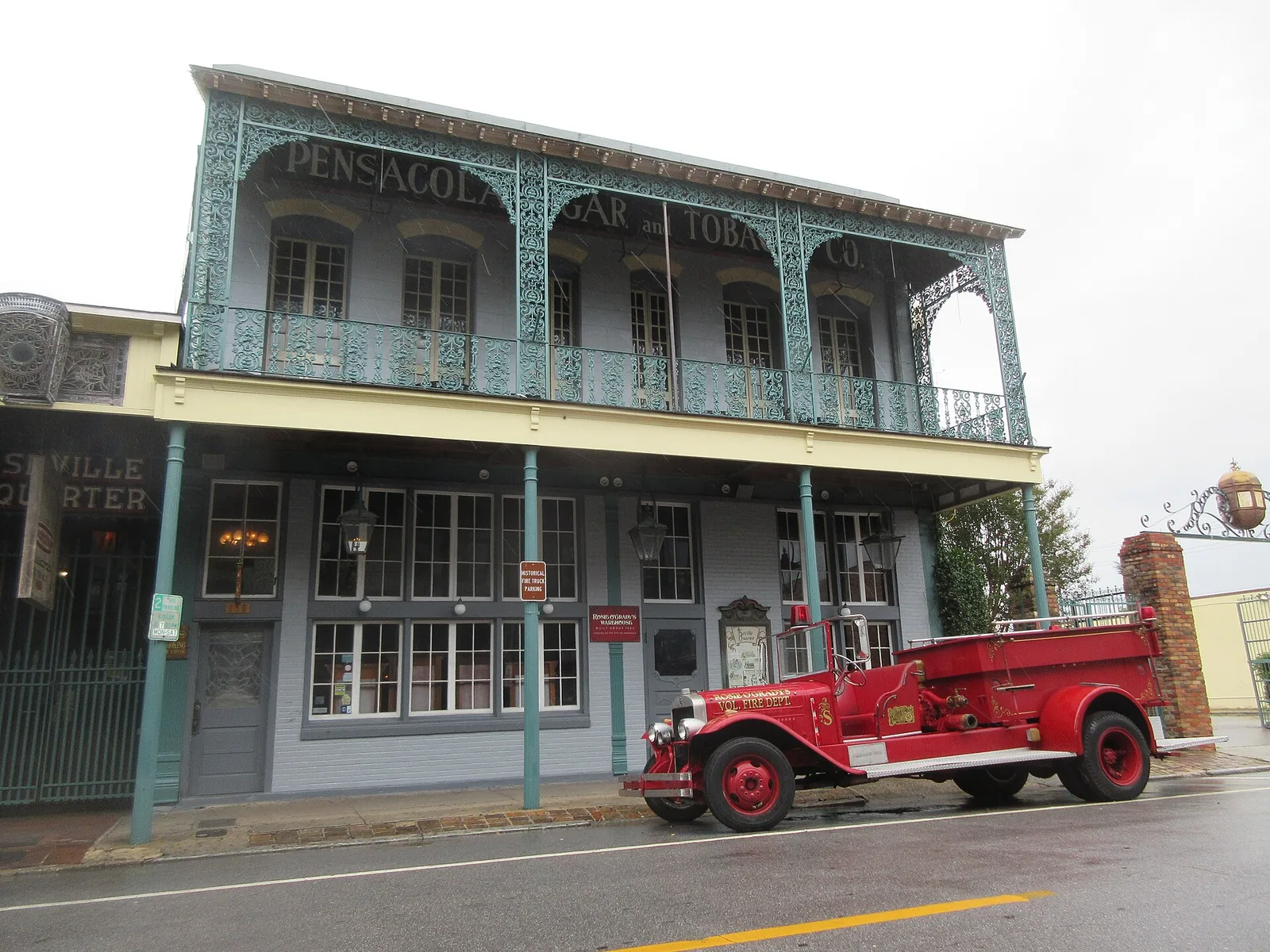The iron gallery of the Pensacola Cigar and Tobacco Co. building at Seville Quarter on Government Street, with a vintage fire engine out front.