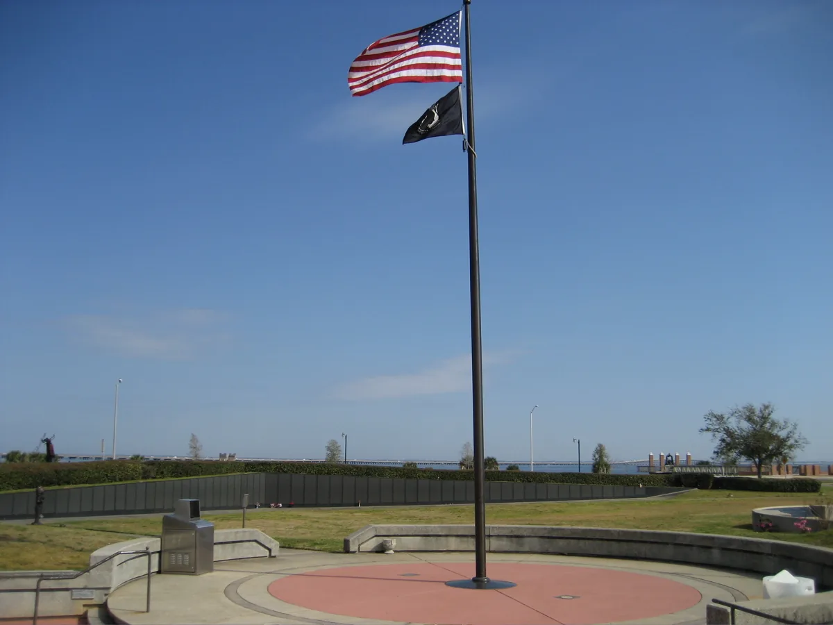 The U.S. and POW-MIA flags fly over Veterans Memorial Park on the Pensacola bayfront, with the Wall South behind.
