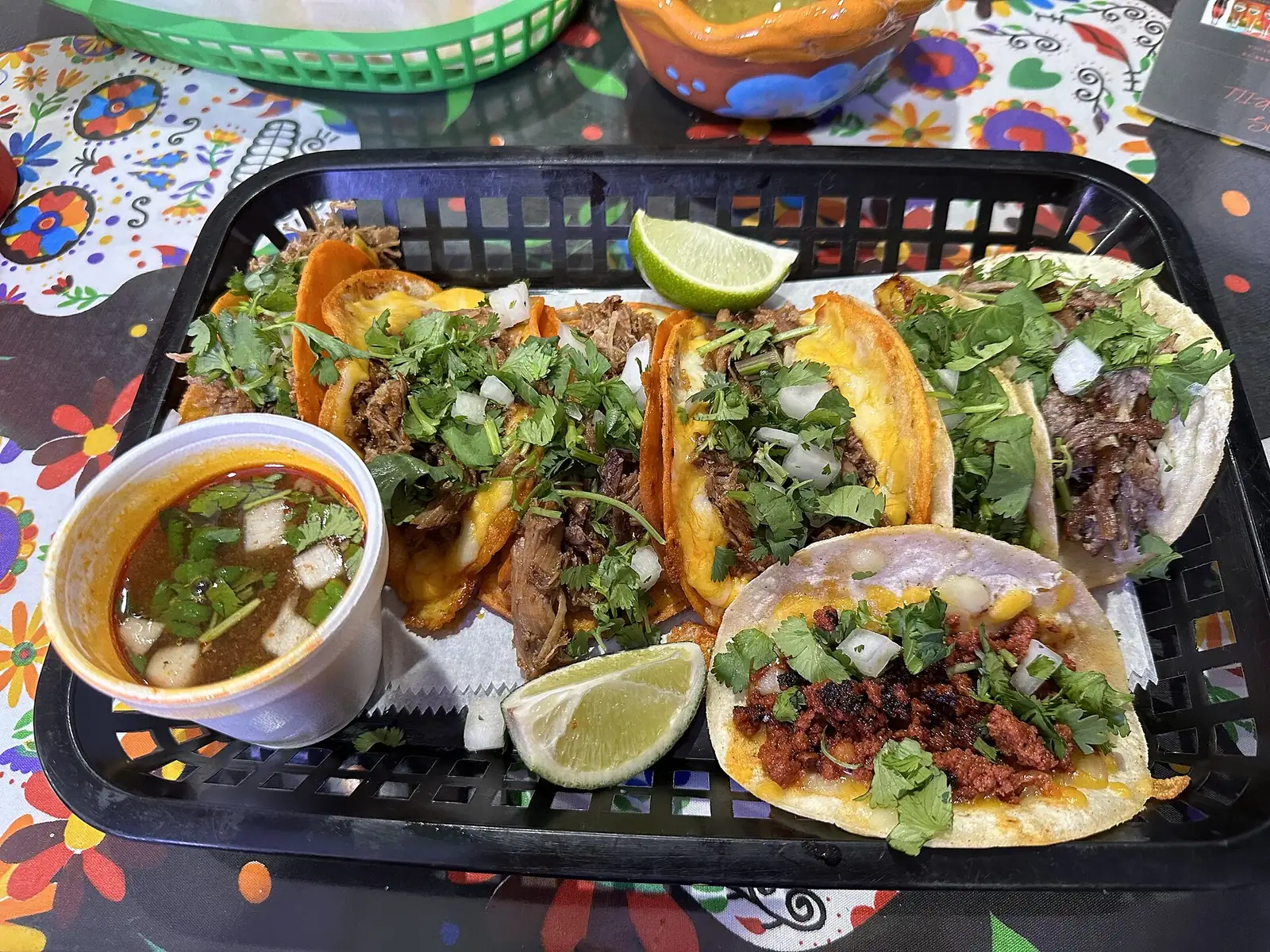 A tray of tacos with lime wedges and a cup of consomme at a Mexican grill in Plantation, Fla., not one of the places on this list.