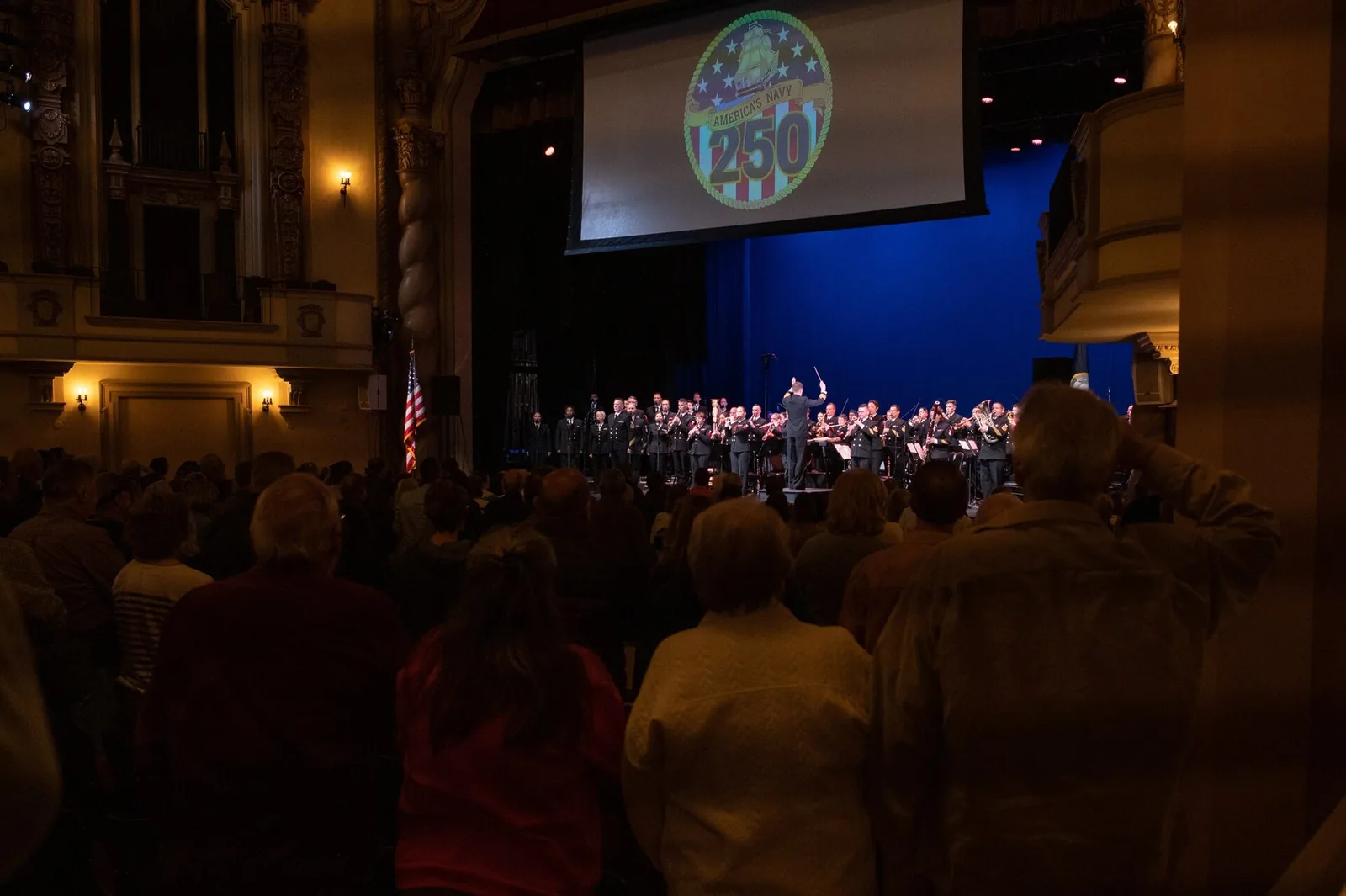 An audience stands for a U.S. Navy Band concert inside the Saenger Theatre on Palafox Place in Pensacola.