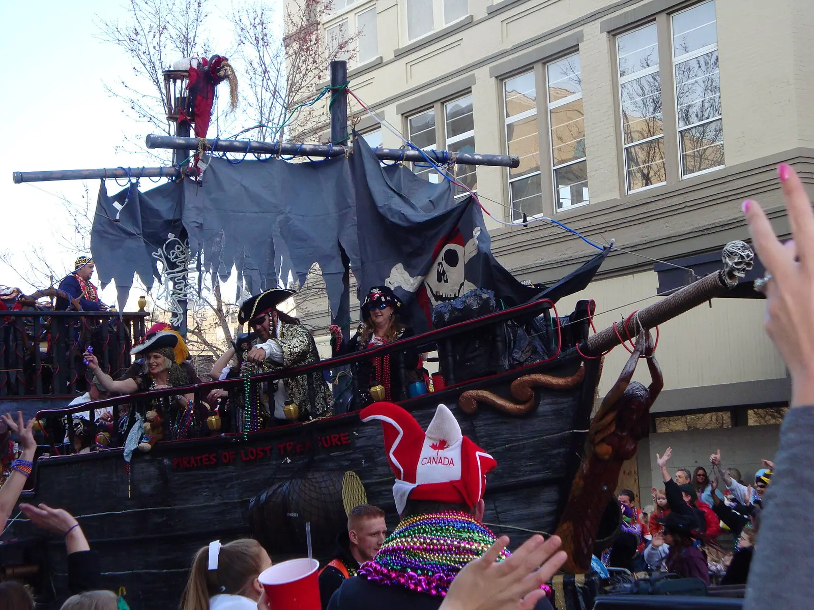 A pirate ship float rolls past crowds downtown during the Pensacola Grand Mardi Gras Parade.