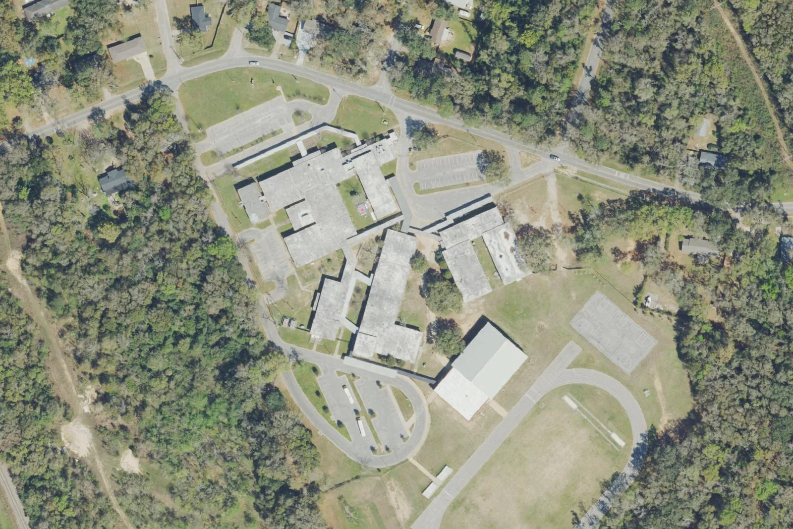 Brown Barge Middle School's buildings and fields among the woods off Hancock Lane north of Pensacola, seen from the air.